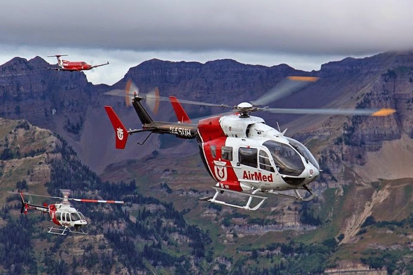 AirMed helicopter ambulance in flight through the mountains