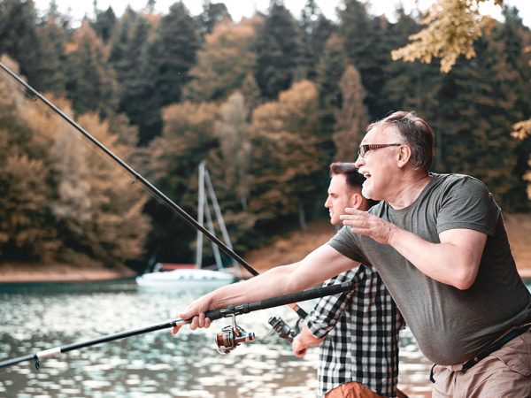 family fishing Dad and Son Fishing at the lake with a boat in the background