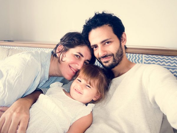 Young Happy Family Mom, dad and young daughter posing for a selfie