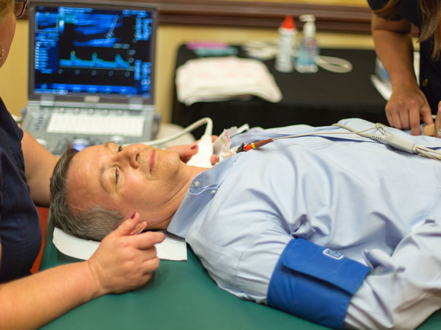 Preventative Screening Man laying on a medical table receiving a carotid artery preventative health screening check via ultrasound