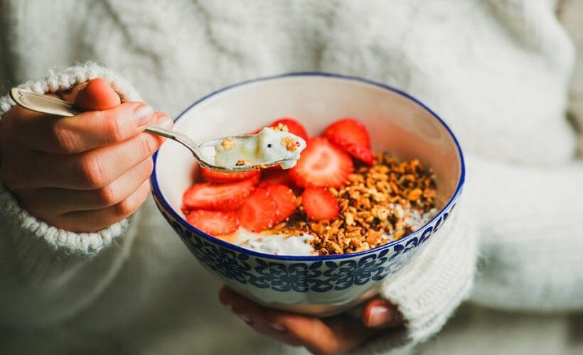Woman holding a bowl of gluten free food for celiac disease diet