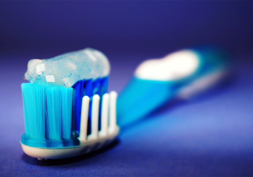 blue and white toothbrush with sparkling toothpaste on top