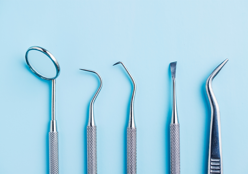 Five silver dentist tools with a blue background use for maintaining oral health